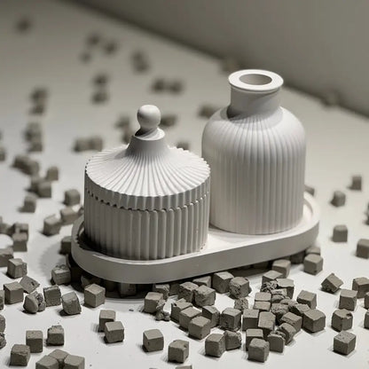 Two containers on a surface with small gray cubes around them.