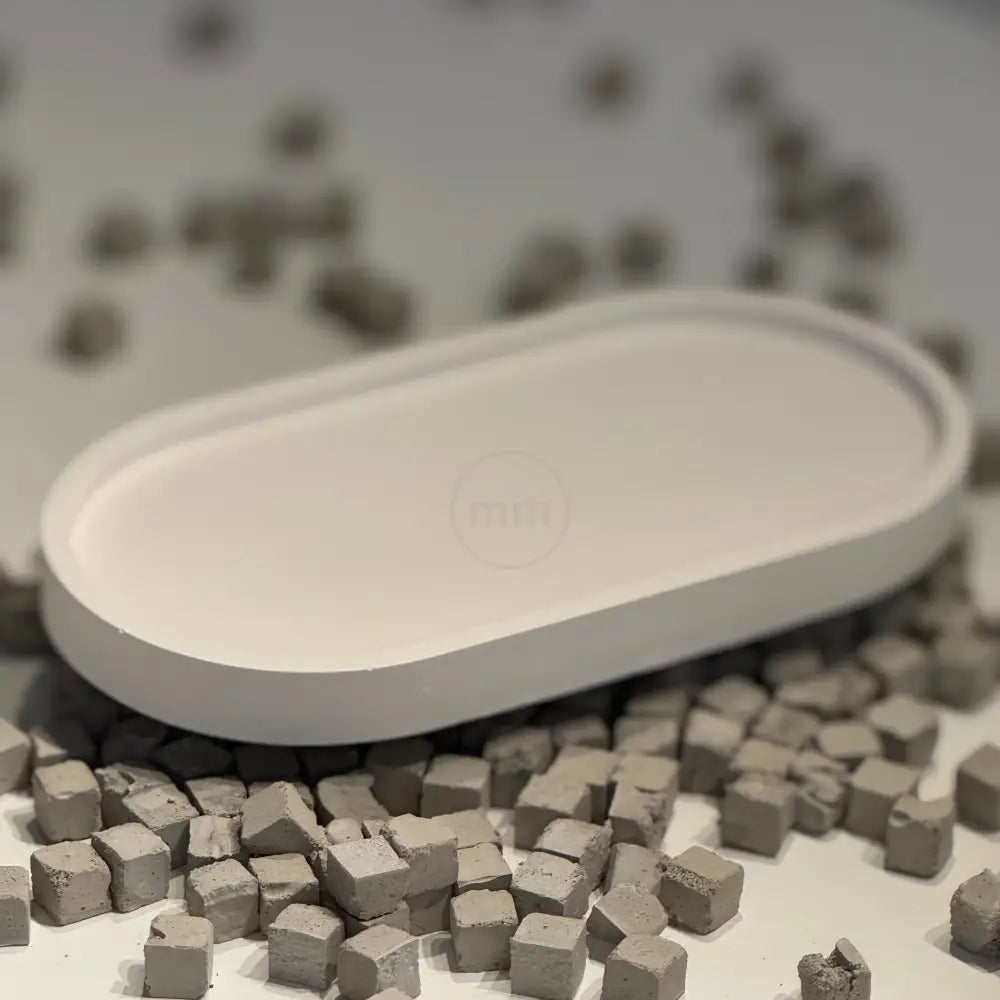 Small white dish with gray cubes on a textured surface