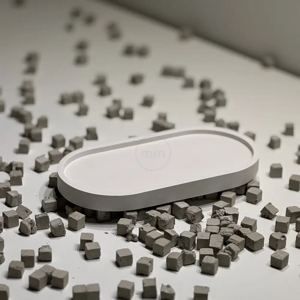 White oval object surrounded by small gray cubes on a white surface