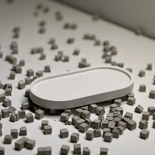 White oval object surrounded by small gray cubes on a white surface